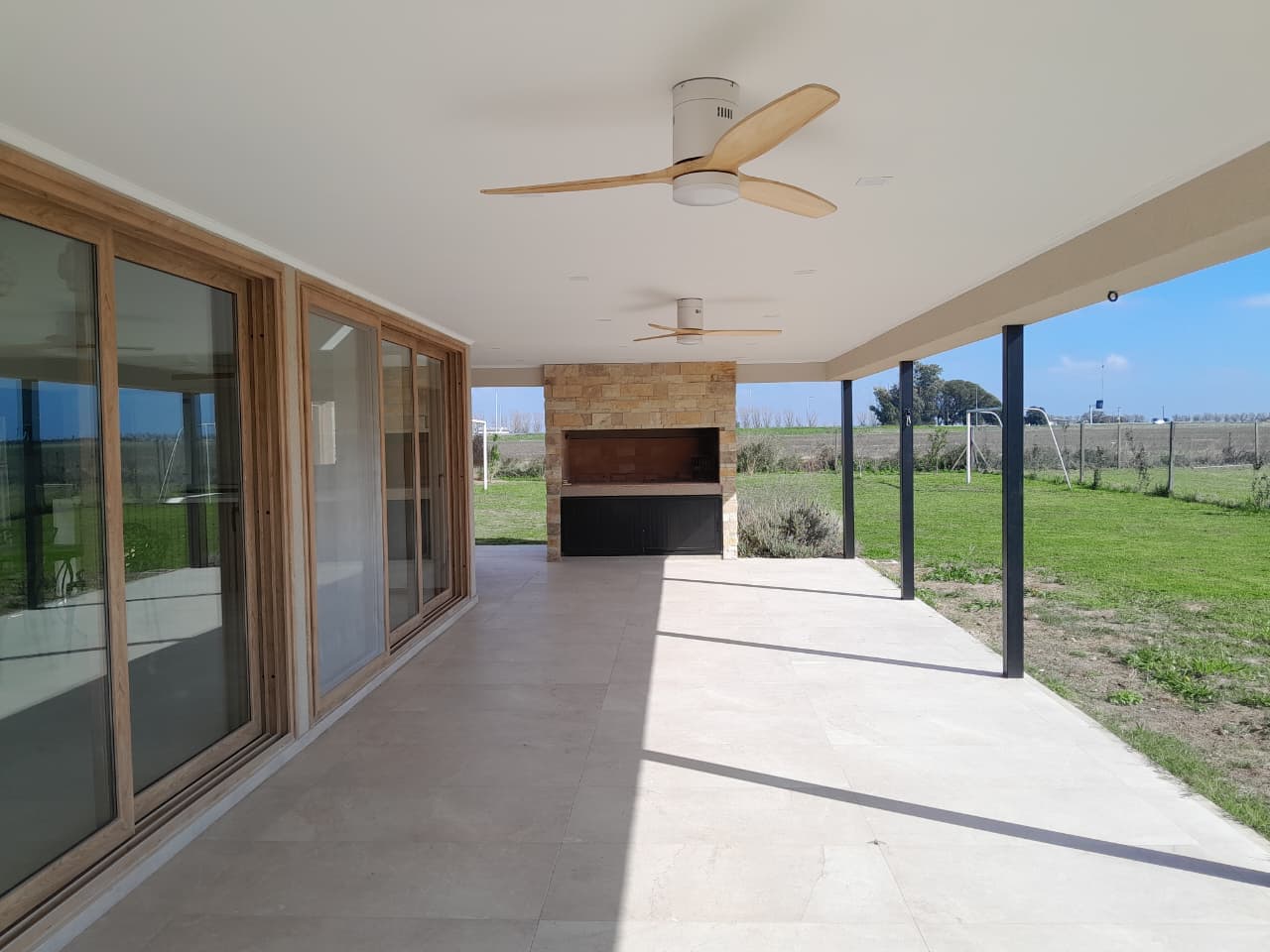 Quincho con asador integrado bajo galería